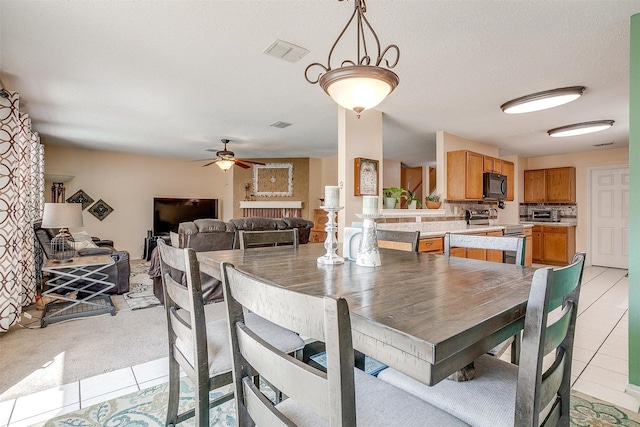 dining room with a textured ceiling, ceiling fan, and light tile patterned floors