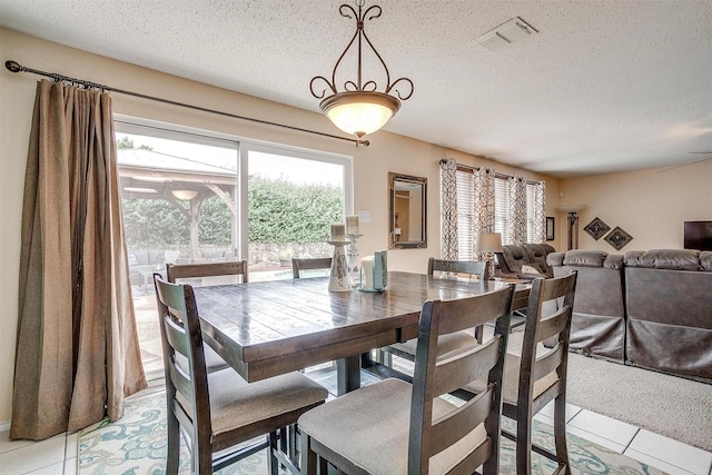 dining room with a textured ceiling and light tile patterned floors