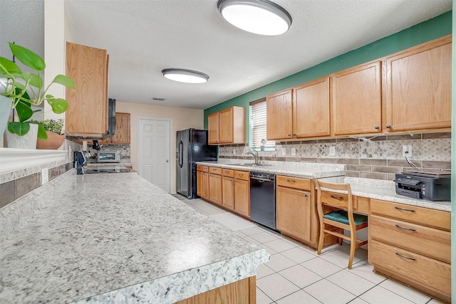 kitchen featuring a textured ceiling, black appliances, decorative backsplash, sink, and light tile patterned flooring