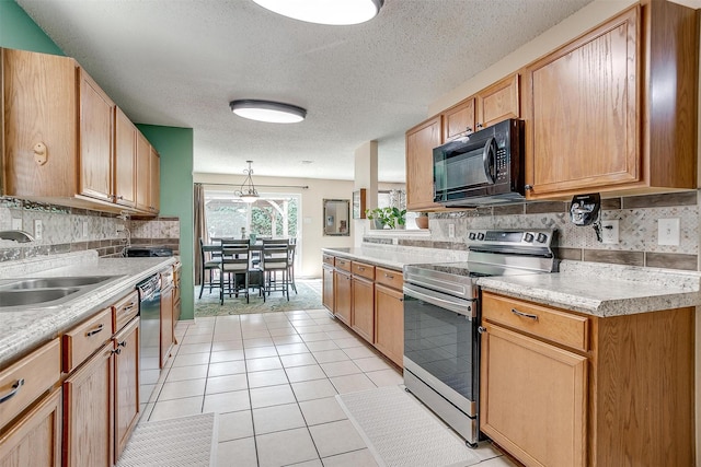 kitchen featuring sink, a textured ceiling, black appliances, and tasteful backsplash