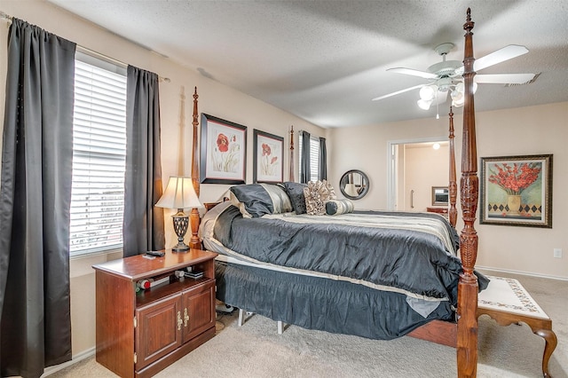 carpeted bedroom featuring a textured ceiling, ceiling fan, and multiple windows