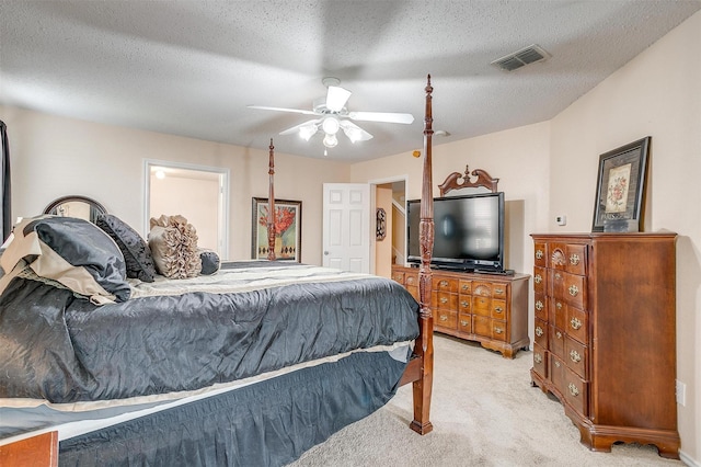 carpeted bedroom featuring ceiling fan and a textured ceiling