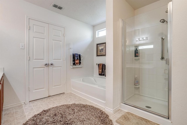 bathroom featuring a textured ceiling, tile patterned flooring, separate shower and tub, and vanity