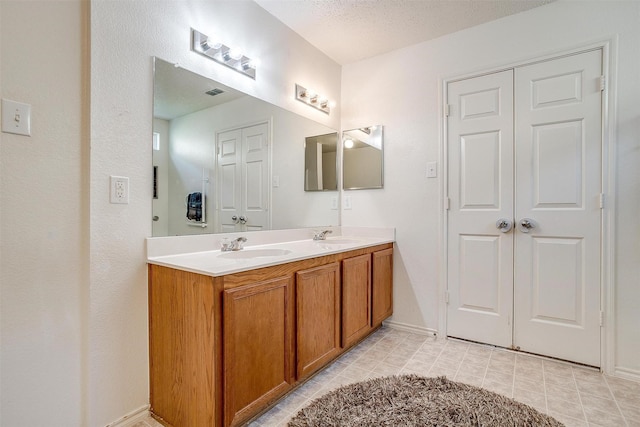 bathroom featuring a textured ceiling and vanity