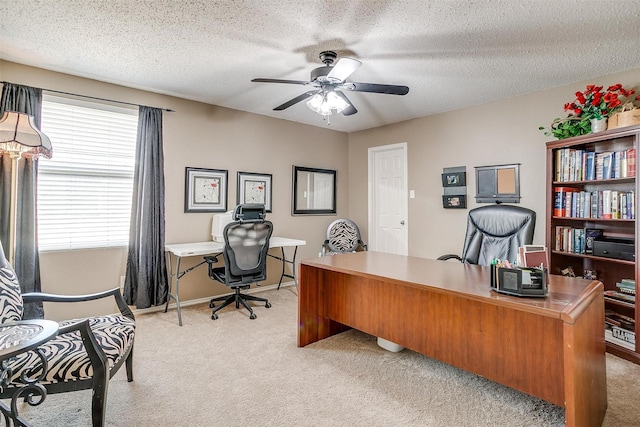 home office with light colored carpet, a healthy amount of sunlight, and a textured ceiling