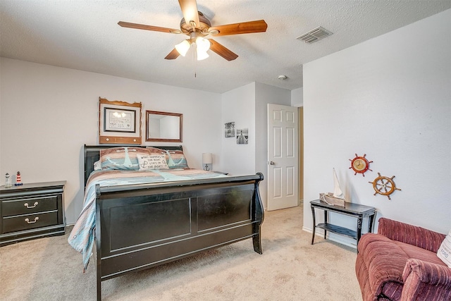 carpeted bedroom featuring ceiling fan and a textured ceiling