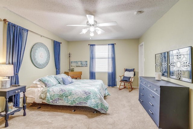 bedroom featuring a textured ceiling, ceiling fan, and light colored carpet