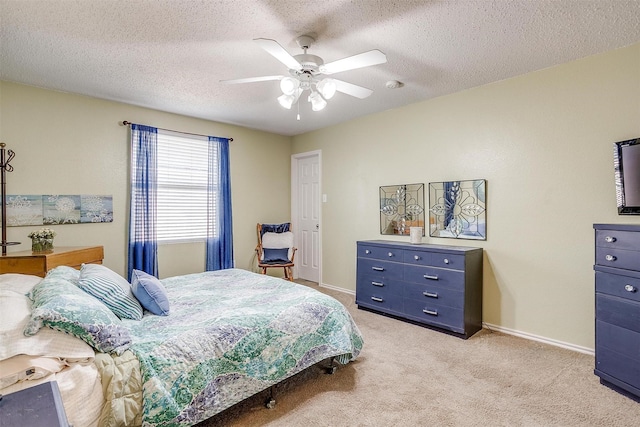 bedroom with ceiling fan, a textured ceiling, and light carpet