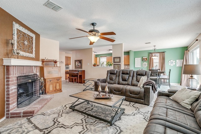 carpeted living room featuring ceiling fan, a textured ceiling, and a fireplace