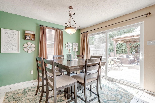 tiled dining area featuring a textured ceiling and a wealth of natural light