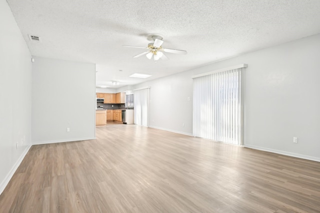 unfurnished living room featuring ceiling fan, a textured ceiling, and light hardwood / wood-style floors