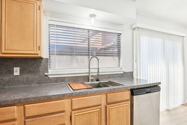 kitchen with light brown cabinetry, stainless steel dishwasher, tasteful backsplash, and sink