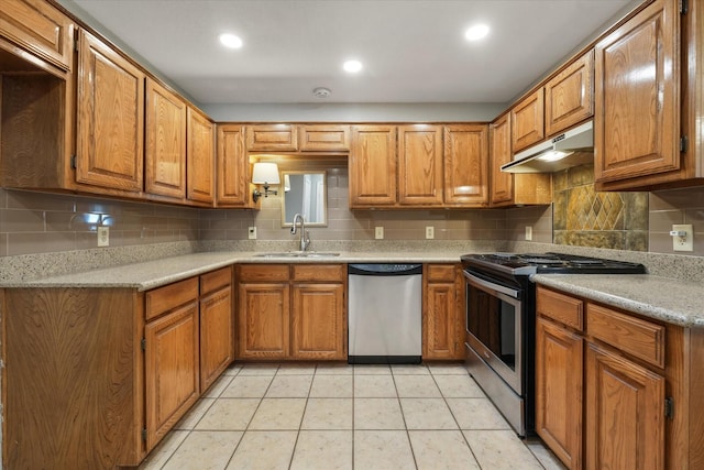 kitchen with brown cabinets, under cabinet range hood, stainless steel appliances, and a sink