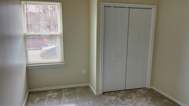 unfurnished bedroom with light carpet and a closet