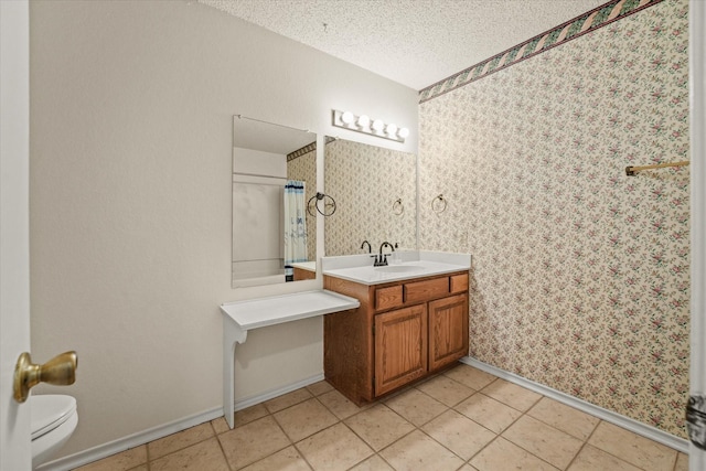 bathroom with wallpapered walls, toilet, tile patterned flooring, a textured ceiling, and vanity