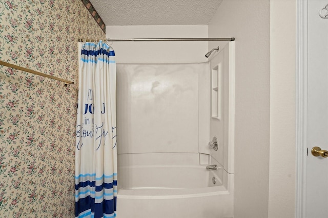 bathroom with shower / tub combo with curtain and a textured ceiling