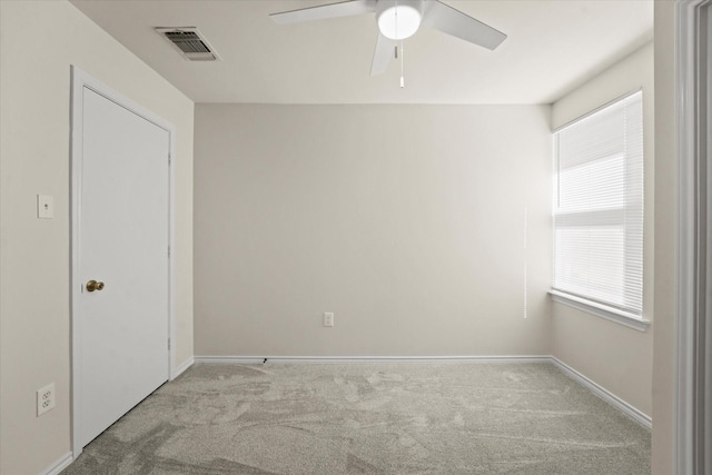 unfurnished room with carpet floors, visible vents, baseboards, and a ceiling fan