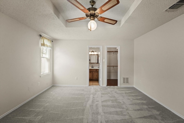 unfurnished bedroom with baseboards, a spacious closet, visible vents, and carpet flooring