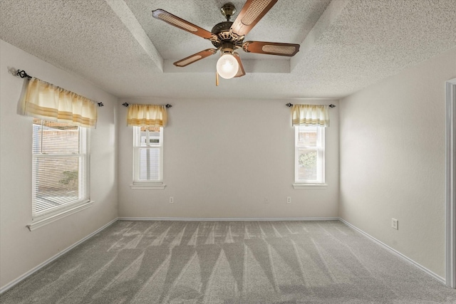 spare room with carpet, plenty of natural light, a textured ceiling, and baseboards