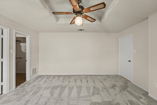 carpeted spare room with baseboards, visible vents, and a textured ceiling