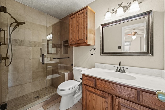 bathroom featuring toilet, a stall shower, a textured ceiling, and vanity