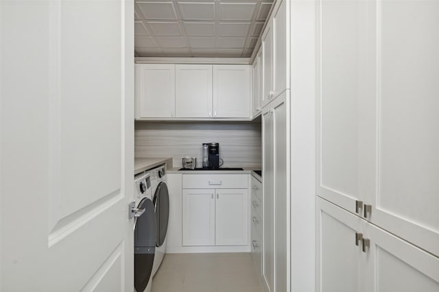 washroom with cabinets and washing machine and clothes dryer