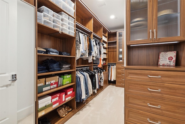 walk in closet featuring light colored carpet