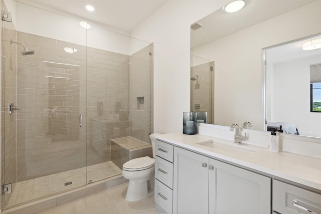 bathroom with tile patterned floors, vanity, toilet, and walk in shower