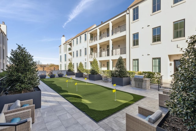 surrounding community with a patio area and an outdoor kitchen