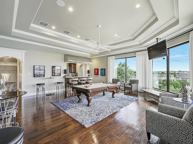 recreation room with billiards, dark wood-type flooring, a tray ceiling, and ornamental molding