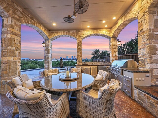 patio terrace at dusk featuring a balcony and a fire pit