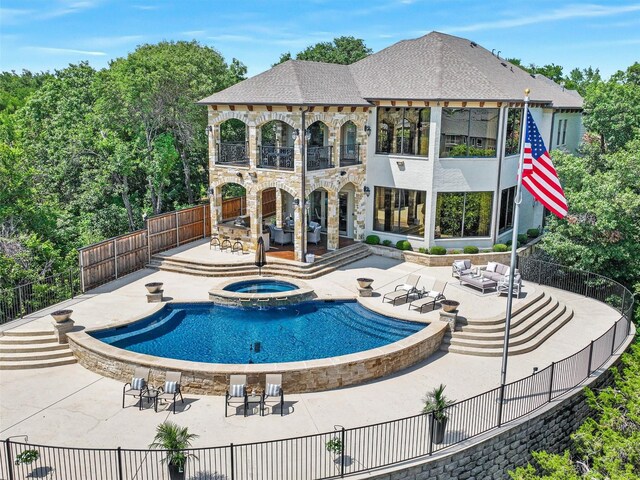 view of swimming pool featuring a patio, a pool with connected hot tub, and fence