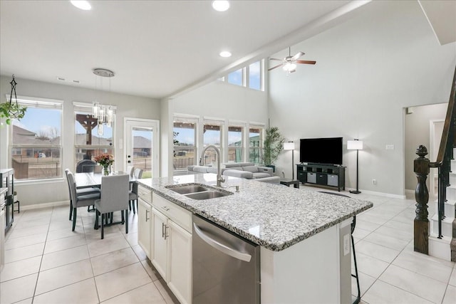 kitchen featuring sink, white cabinetry, light stone counters, a center island with sink, and stainless steel dishwasher