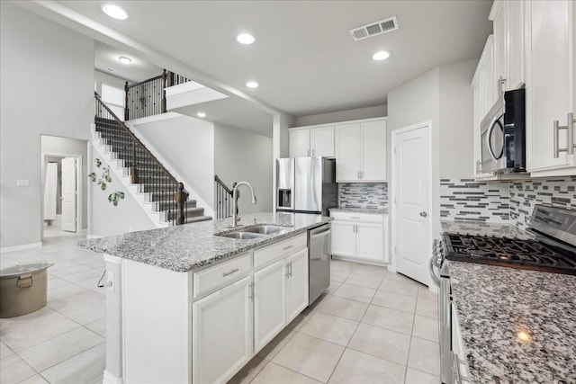 kitchen featuring a kitchen island with sink, sink, white cabinetry, and appliances with stainless steel finishes