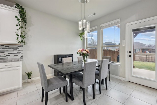 tiled dining area with an inviting chandelier and plenty of natural light