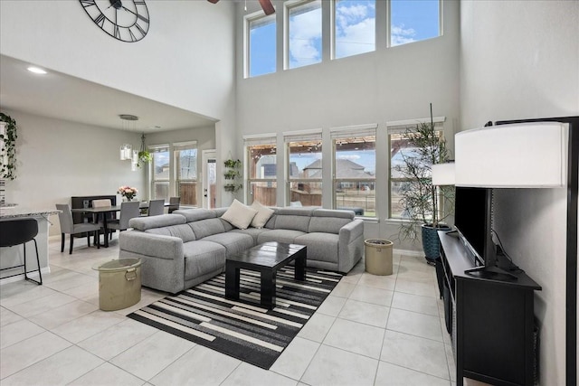 living room with a high ceiling and light tile patterned flooring