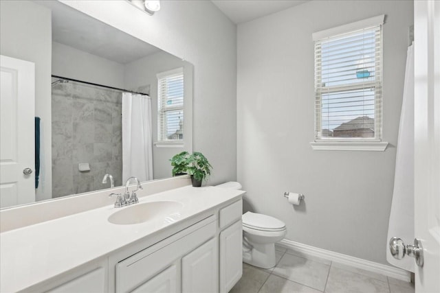 bathroom featuring tile patterned flooring, vanity, toilet, and a healthy amount of sunlight