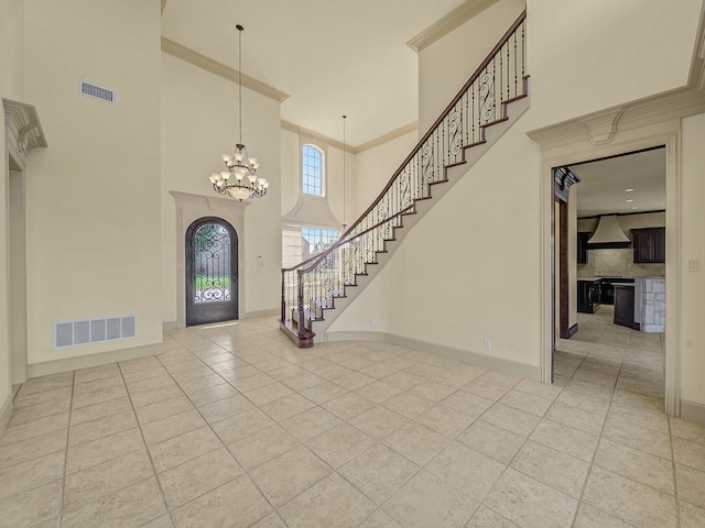 entryway with an inviting chandelier and a towering ceiling