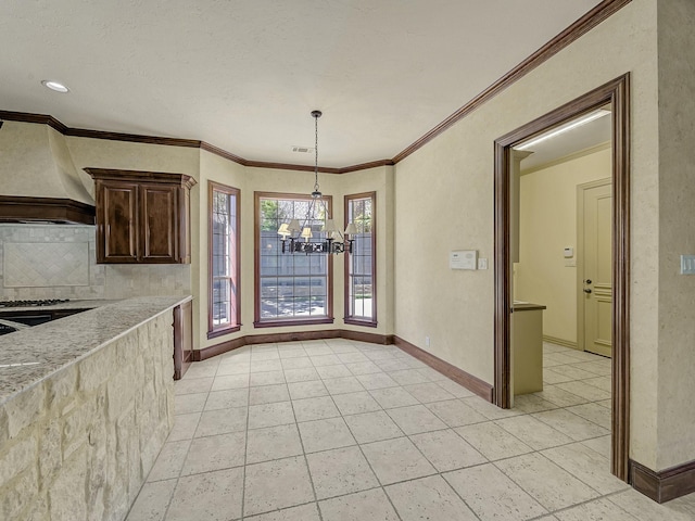 unfurnished dining area with crown molding and an inviting chandelier