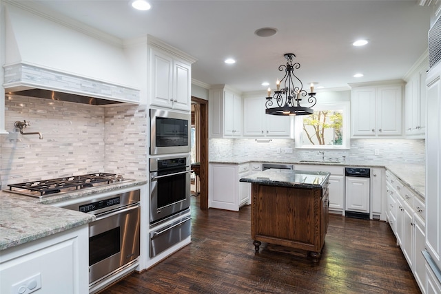 kitchen featuring light stone countertops, premium range hood, and white cabinetry