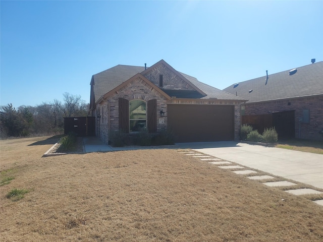 view of front of property with a garage, driveway, brick siding, and a front yard