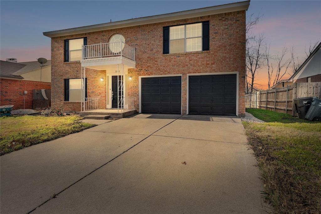 view of front of house with a garage, a lawn, and a balcony