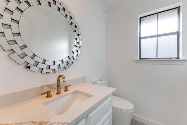 bathroom with vanity, crown molding, and toilet