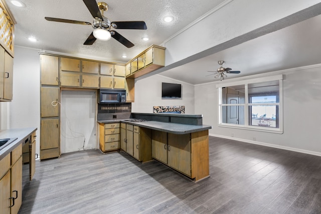 kitchen featuring a textured ceiling, hardwood / wood-style flooring, ornamental molding, and kitchen peninsula