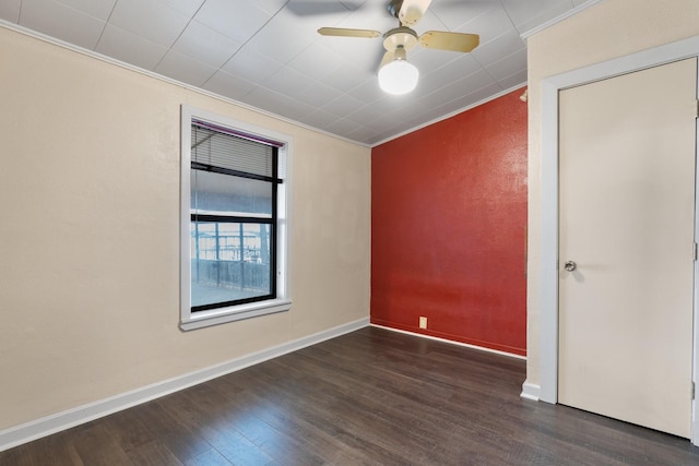 unfurnished room featuring ceiling fan, dark wood-type flooring, and crown molding