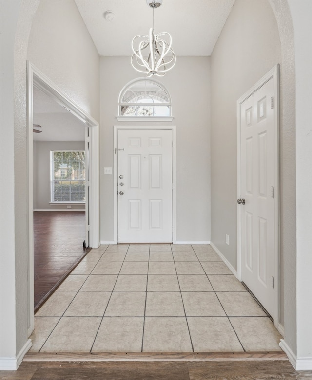 entrance foyer with light tile patterned floors and an inviting chandelier