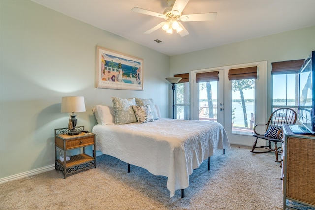 bedroom featuring ceiling fan, access to exterior, light colored carpet, and french doors