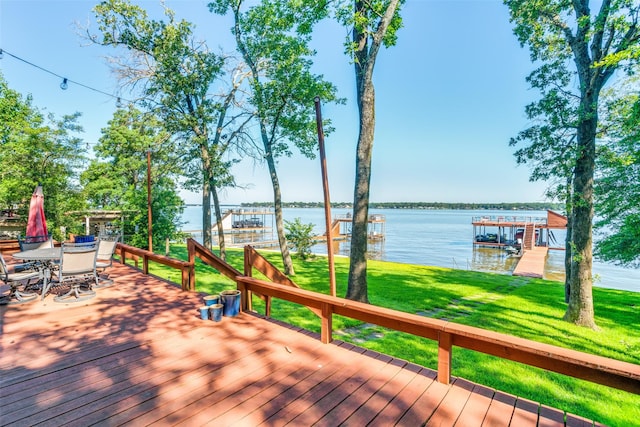 wooden deck with a water view and a lawn