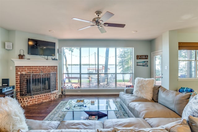 living room featuring a fireplace, a wealth of natural light, and dark hardwood / wood-style floors