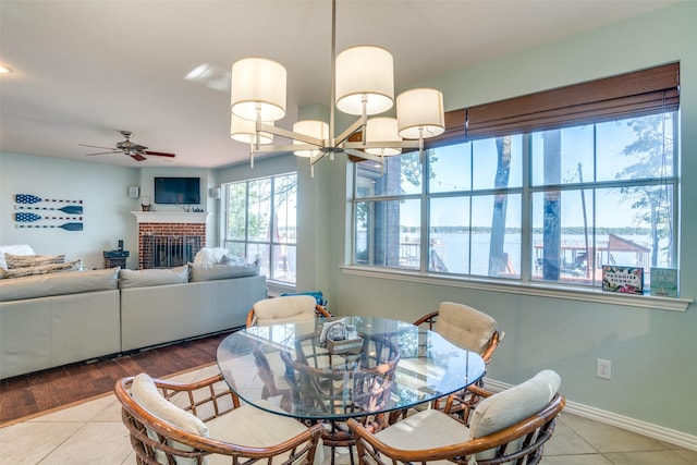 dining space featuring ceiling fan, a fireplace, and hardwood / wood-style flooring